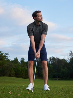 Model in dark grey/black your favorite jacquard polo preparing to tee off, full-body shot