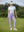 Woman wearing Women's Ultra-stretch Quick Dry Sweatpants with Ankle Zips in lavender, holding golf club on course