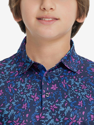 Front view of youth wearing navy colorful flower performance print boys golf polo, showing collar and chest fit