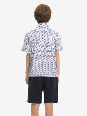 Back half-body view of youth wearing white purple shark performance print boys golf polo, showing rear design